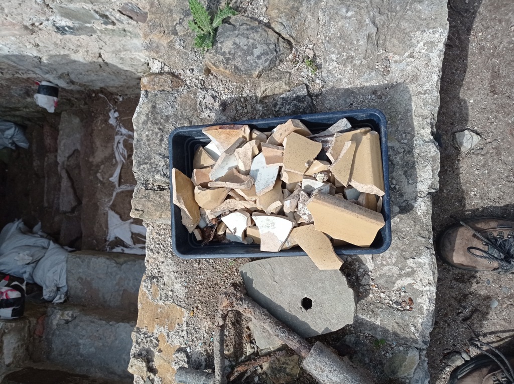 A finds tray on the extant tower wall is full of thick sherds of yellow and white ceramic.